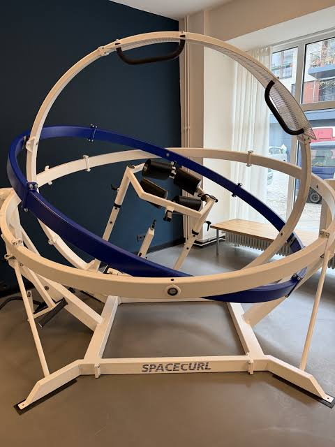 Der Spacecurl aus der Nähe: zwei ineinander gelagerte Metallringe in einem Standrahmen.